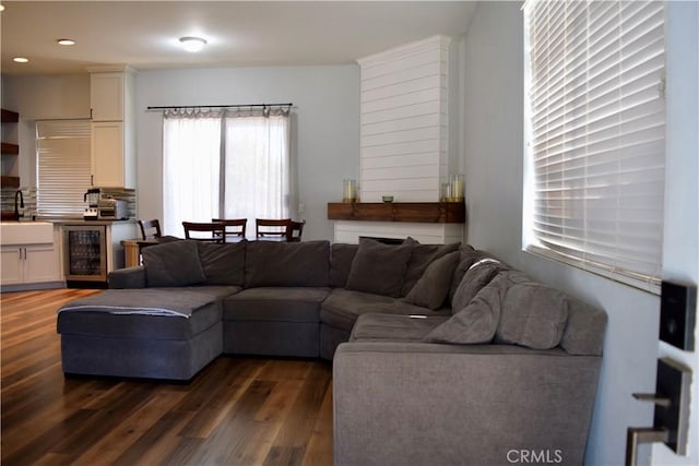 living room featuring beverage cooler, dark wood-type flooring, and recessed lighting