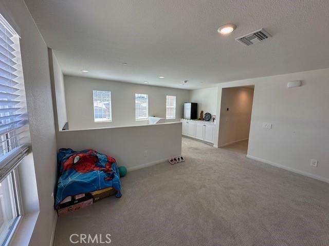 interior space featuring visible vents, baseboards, and light colored carpet