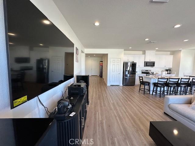 living area featuring light wood-style flooring and recessed lighting