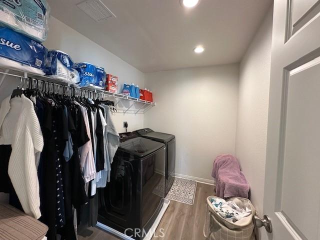 clothes washing area with wood finished floors, visible vents, laundry area, recessed lighting, and washer and clothes dryer