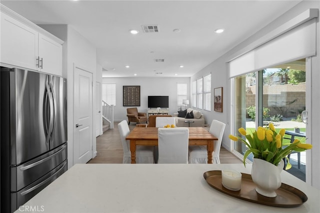 dining room with light wood-style floors, stairway, visible vents, and recessed lighting