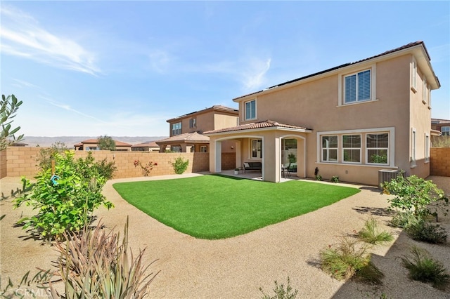 back of house featuring cooling unit, a fenced backyard, a lawn, stucco siding, and a patio area