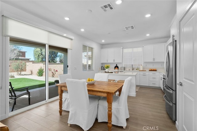 dining area with light wood-type flooring, recessed lighting, and visible vents