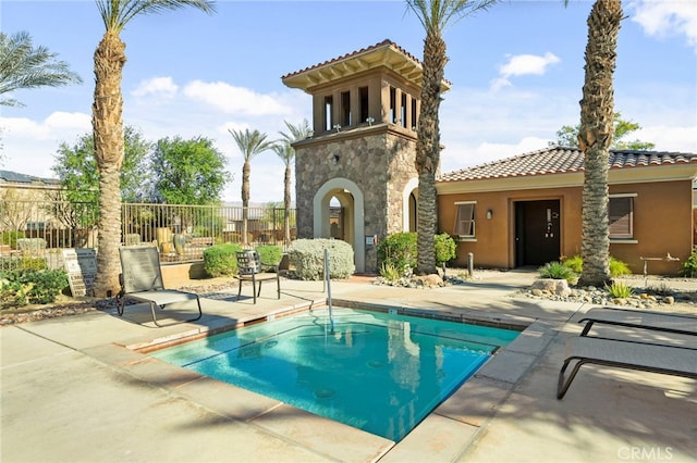 view of swimming pool featuring a swimming pool, fence, and a patio