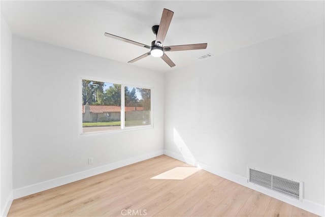 spare room featuring visible vents, ceiling fan, baseboards, and wood finished floors