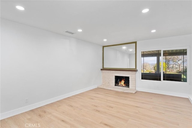 unfurnished living room featuring light wood-type flooring, visible vents, baseboards, and recessed lighting