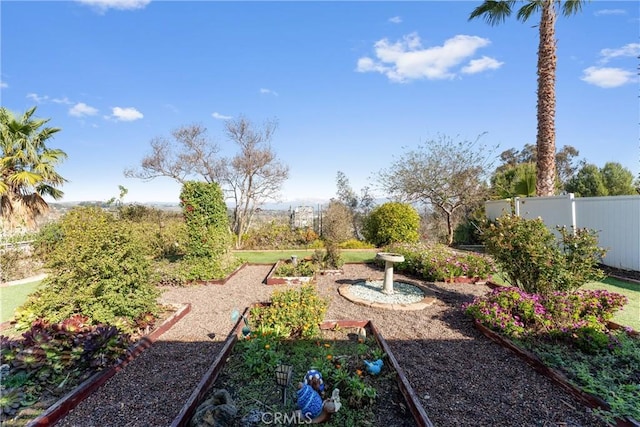 view of yard featuring fence and a garden