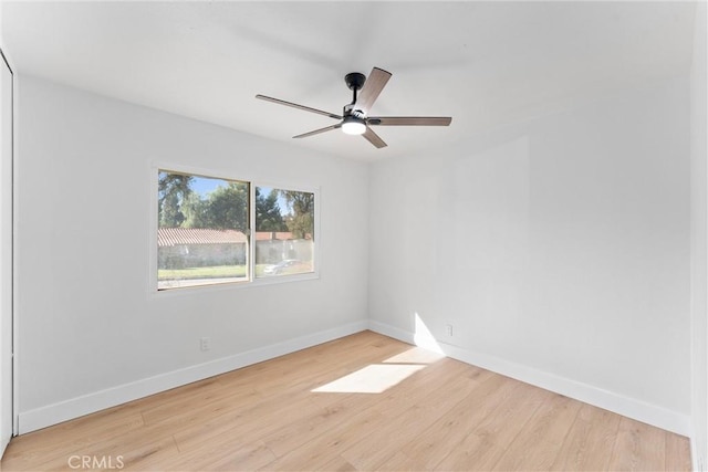 unfurnished room with a ceiling fan, baseboards, and wood finished floors