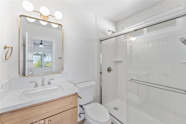 bathroom featuring vanity, a shower stall, and toilet