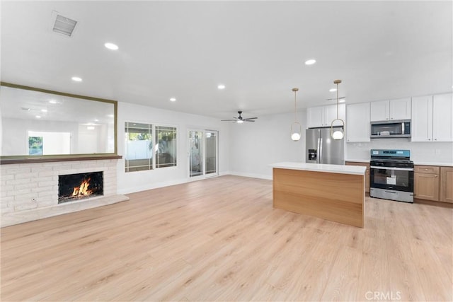 kitchen with visible vents, open floor plan, light countertops, appliances with stainless steel finishes, and light wood finished floors