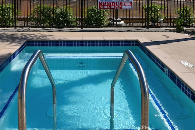 view of swimming pool featuring fence