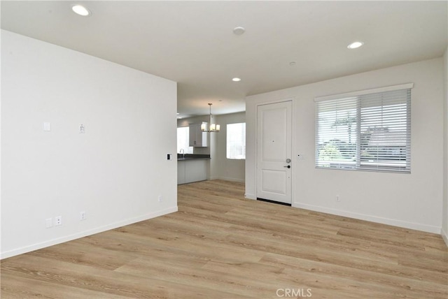 empty room with baseboards, light wood-style flooring, and recessed lighting