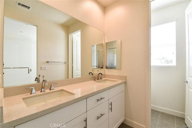 full bath with double vanity, visible vents, a sink, and tile patterned floors