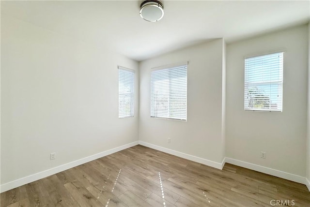 empty room with wood finished floors and baseboards