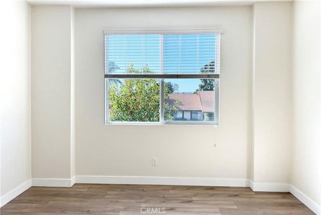 unfurnished room featuring light wood-type flooring and baseboards