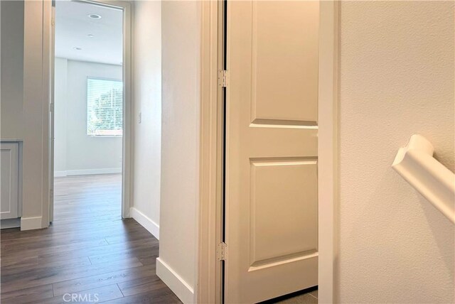 hall featuring baseboards and wood finished floors