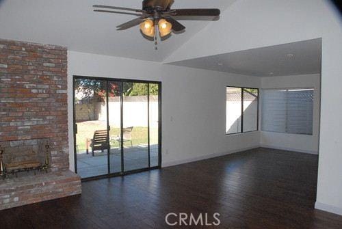 empty room featuring a ceiling fan, lofted ceiling, and wood finished floors