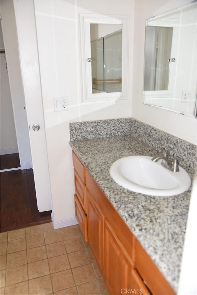 bathroom featuring vanity, baseboards, and tile patterned flooring