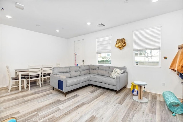 living area with recessed lighting, visible vents, baseboards, and wood finished floors