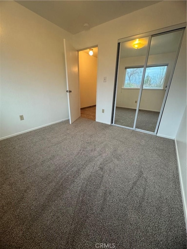 unfurnished bedroom featuring a closet, carpet flooring, and baseboards