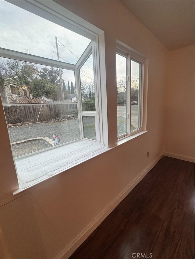 unfurnished room with dark wood-style floors and baseboards