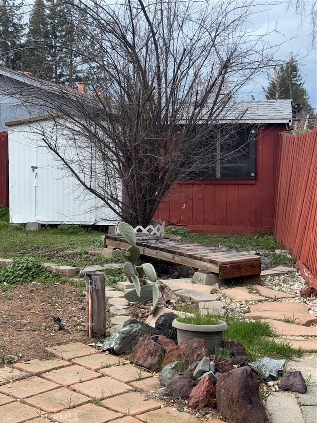 view of yard with an outbuilding, fence, and a shed