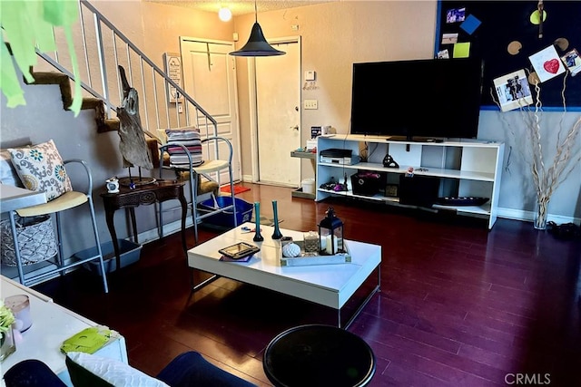 living area with stairs, baseboards, and wood finished floors