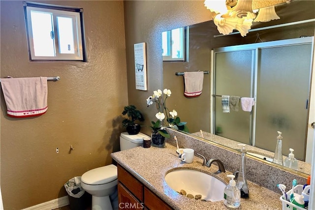 full bath featuring a textured wall, vanity, a shower stall, and toilet