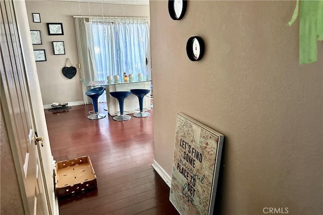 hall with baseboards and hardwood / wood-style floors