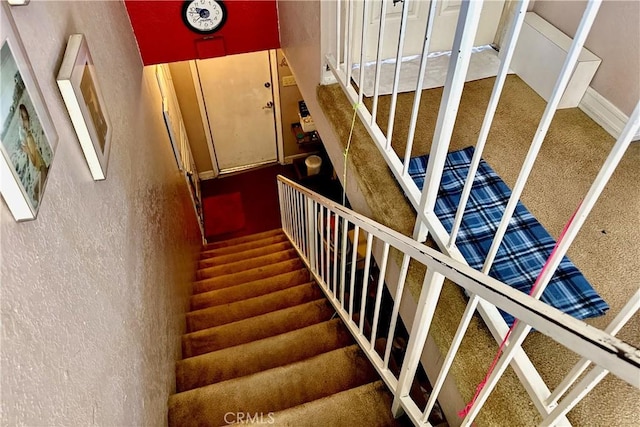 stairway featuring a textured wall