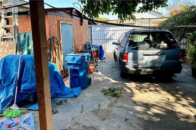 view of vehicle parking with fence