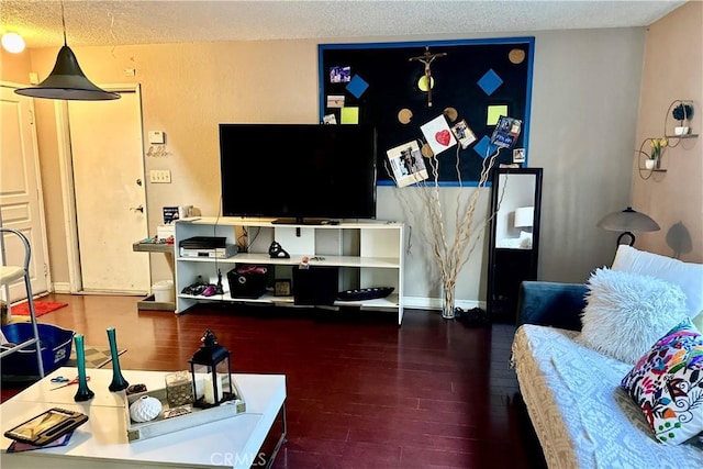 living area with a textured ceiling, wood finished floors, and baseboards