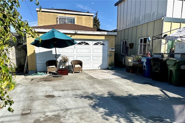 view of side of home with a garage, fence, and board and batten siding