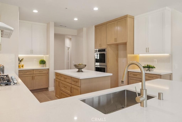 kitchen featuring light countertops, recessed lighting, light wood-style floors, stainless steel appliances, and a sink