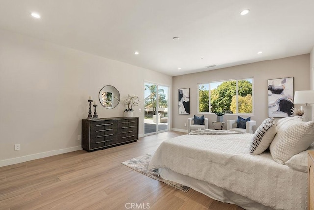 bedroom with light wood-type flooring, baseboards, and access to outside