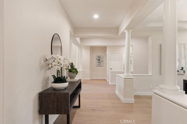 hallway with recessed lighting, baseboards, light wood-style flooring, and ornate columns