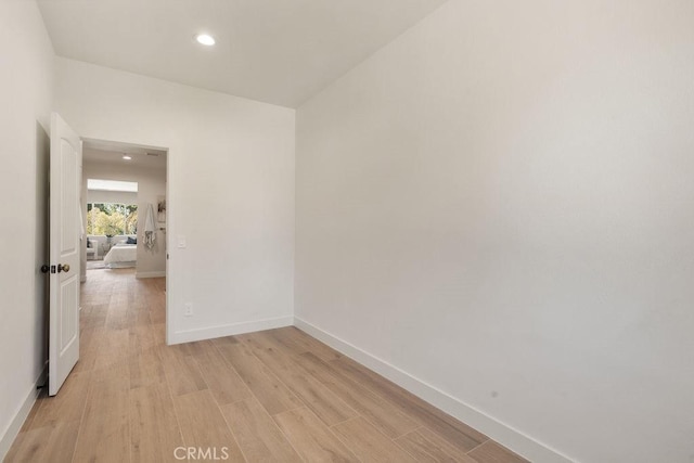 spare room featuring recessed lighting, light wood-style flooring, and baseboards