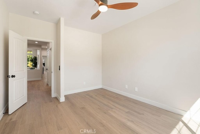 unfurnished room with ceiling fan, baseboards, and light wood-style floors