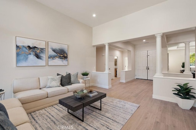 living area with light wood finished floors, recessed lighting, baseboards, and decorative columns