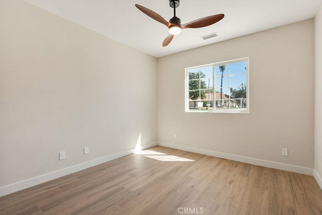 spare room featuring visible vents, baseboards, light wood-style floors, and a ceiling fan