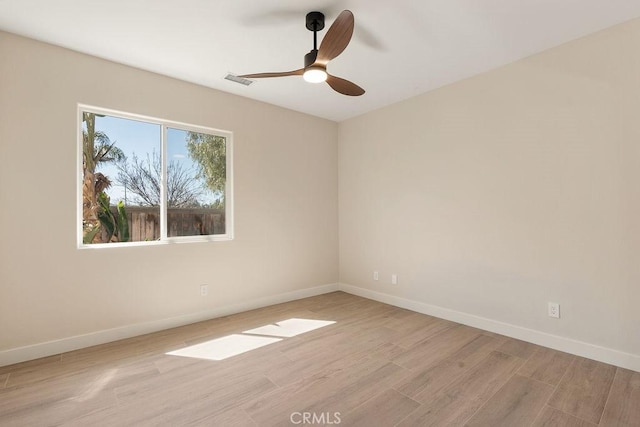 spare room featuring visible vents, baseboards, a ceiling fan, and light wood finished floors