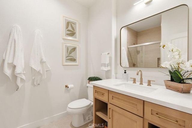 bathroom featuring vanity, a shower stall, toilet, and baseboards