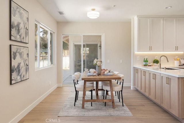 dining area featuring visible vents, baseboards, and light wood-style floors