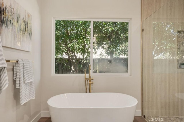 bathroom featuring baseboards and a soaking tub