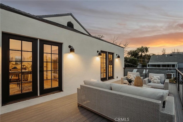 deck at dusk featuring an outdoor hangout area