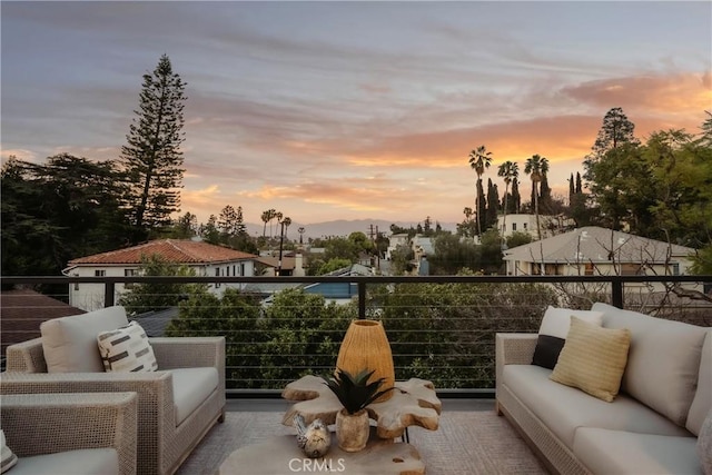 patio terrace at dusk featuring an outdoor living space and a balcony