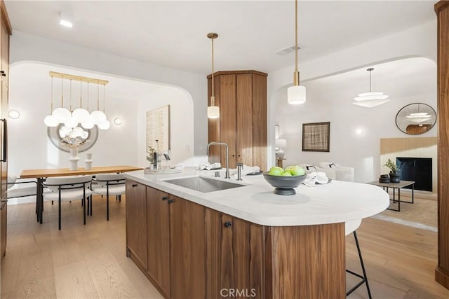 kitchen featuring light countertops, visible vents, a sink, and light wood finished floors