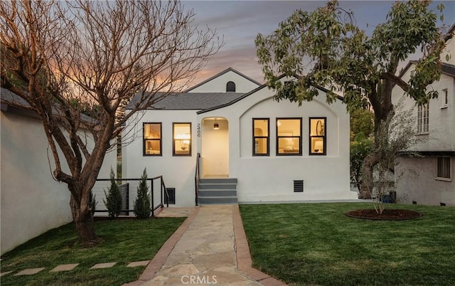 view of front of house featuring stucco siding and a front yard