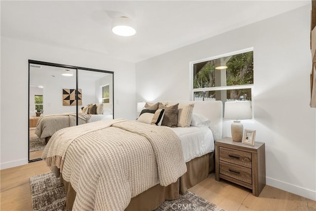 bedroom featuring baseboards and light wood finished floors