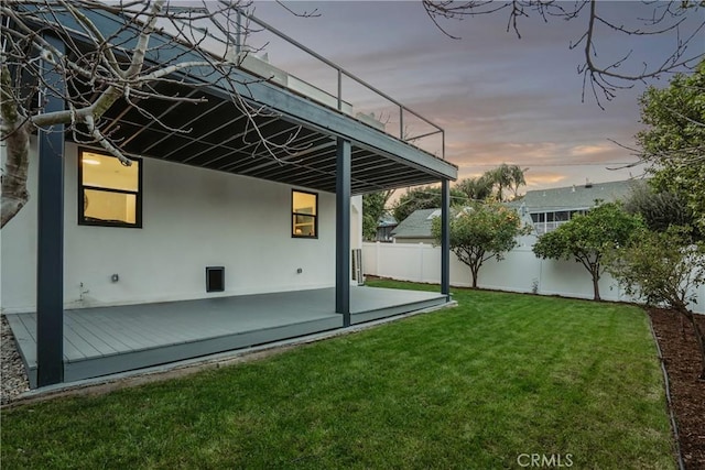 exterior space featuring fence, a lawn, and stucco siding